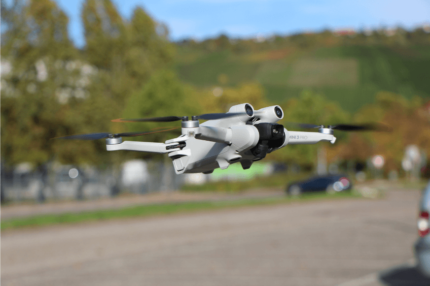 Die DJI Mini 3 Pro schwebt waagrecht in der Luft.